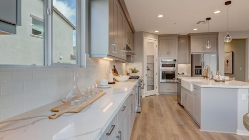 Open-concept kitchen with quartz countertops and stainless steel appliances