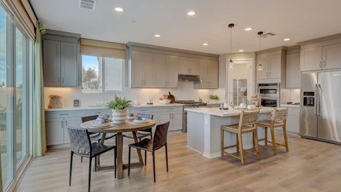 Open-concept kitchen with quartz countertops and stainless steel appliances with dining nook