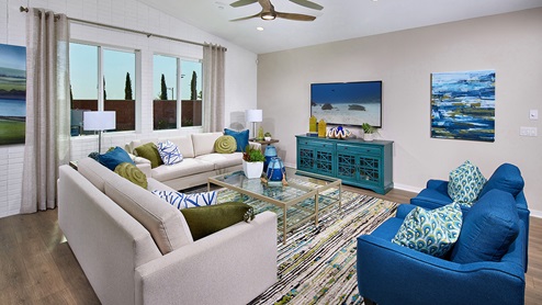 Vista Verde in Highland model home great room with blue chairs and wood flooring