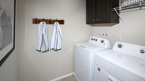 Laundry room with dark brown upper cabinets