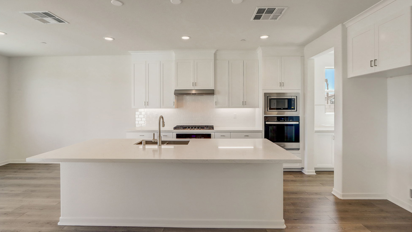 Kitchen with white cabinets quartz countertops and stainless steel appliances