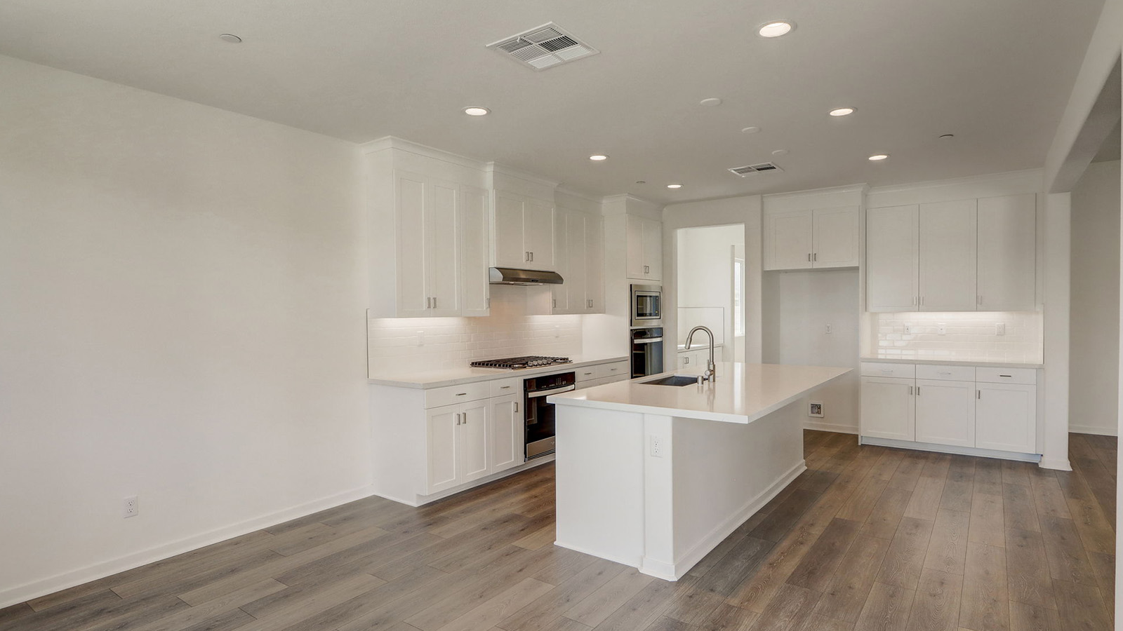 Kitchen with white cabinets quartz countertops and stainless steel appliances