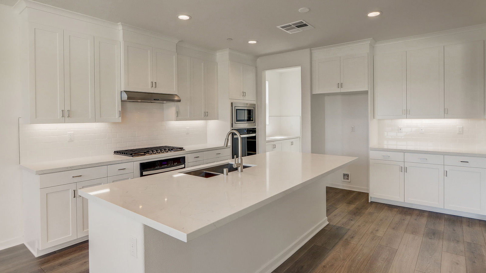 Kitchen with white cabinets quartz countertops and stainless steel appliances