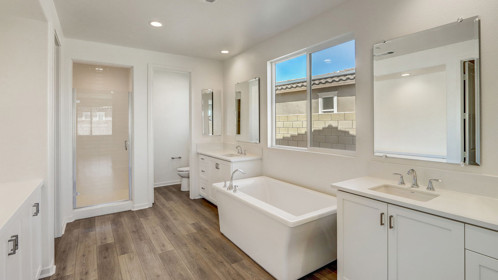 Primary bathroom with dual vanities and shower and free standing tub