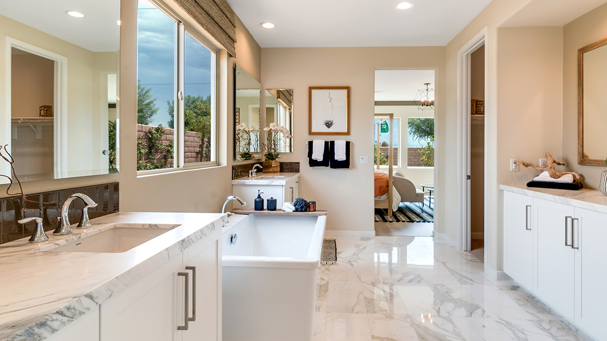 Primary bathroom with dual vanities and free standing tub