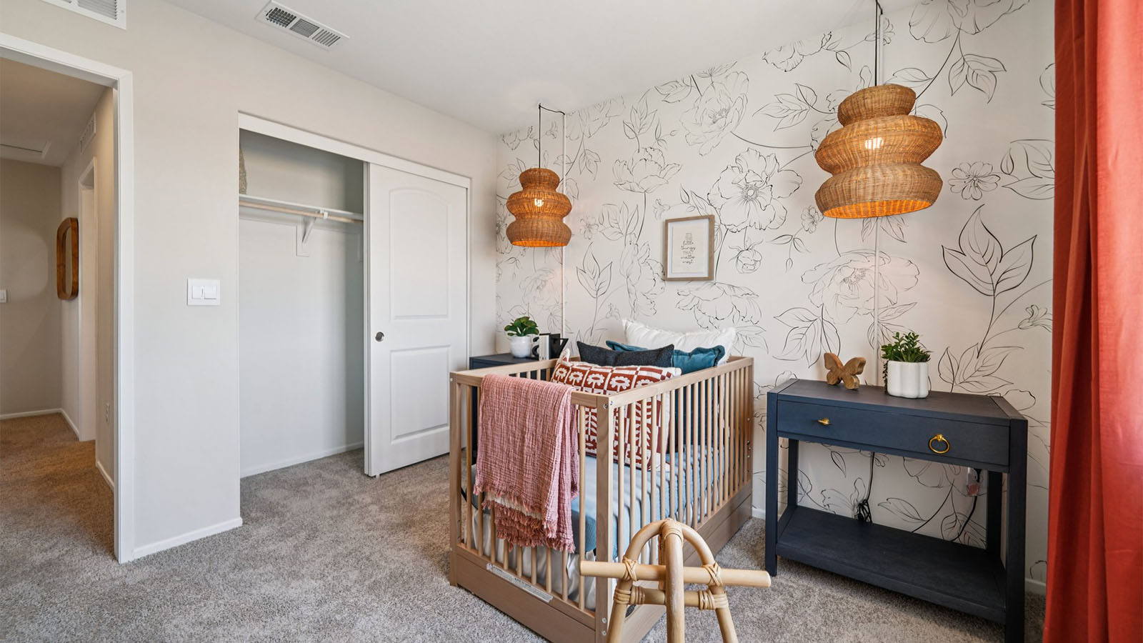 Nursery with plush caret and wallpaper accent wall