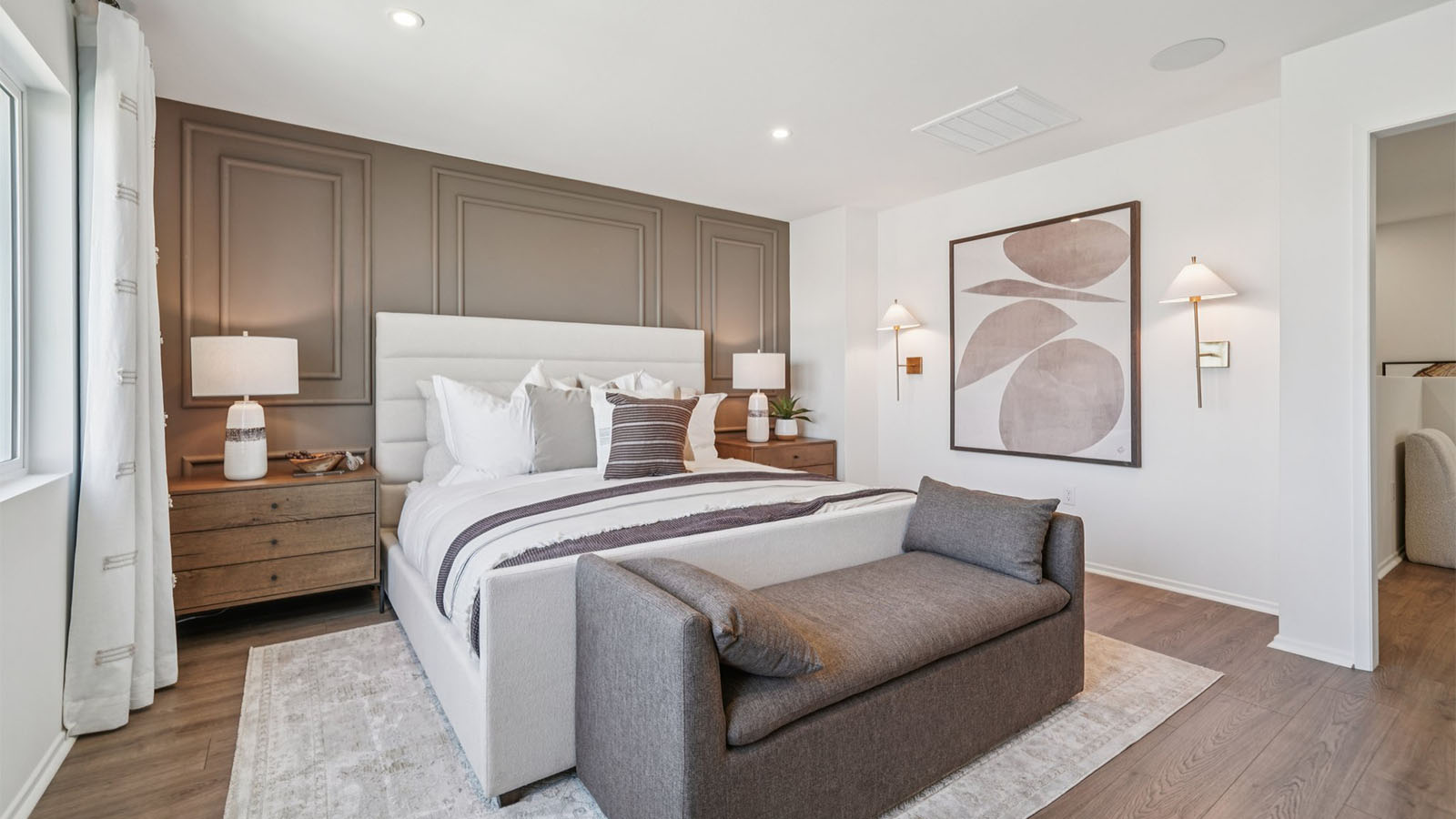Primary bedroom with king bed and laminate wood flooring