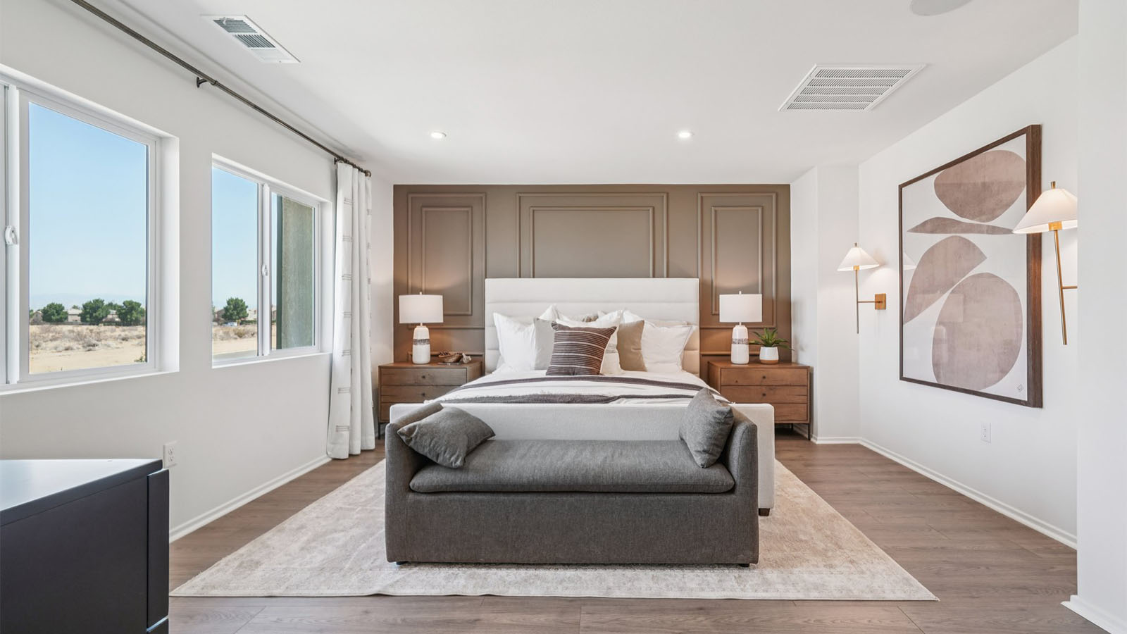 Primary bedroom with king bed and laminate wood flooring