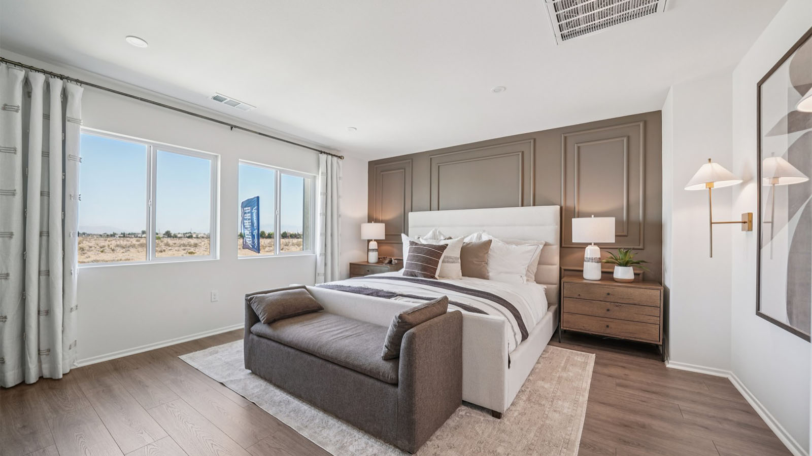Primary bedroom with king bed and laminate wood flooring