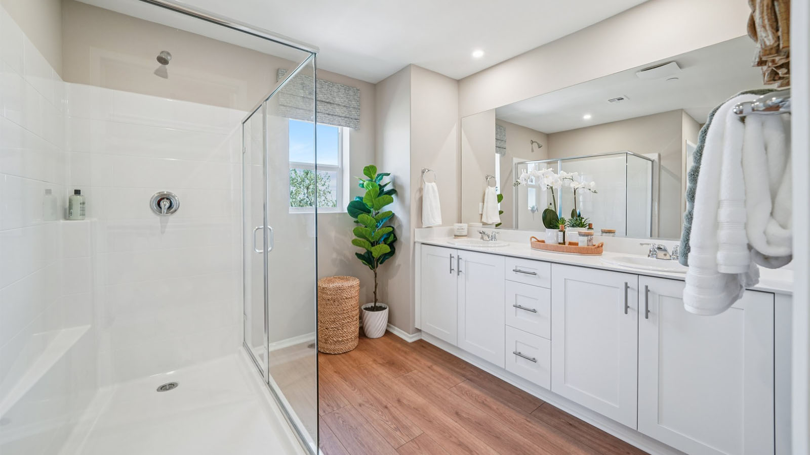 Primary bathroom with dual vanities and shower