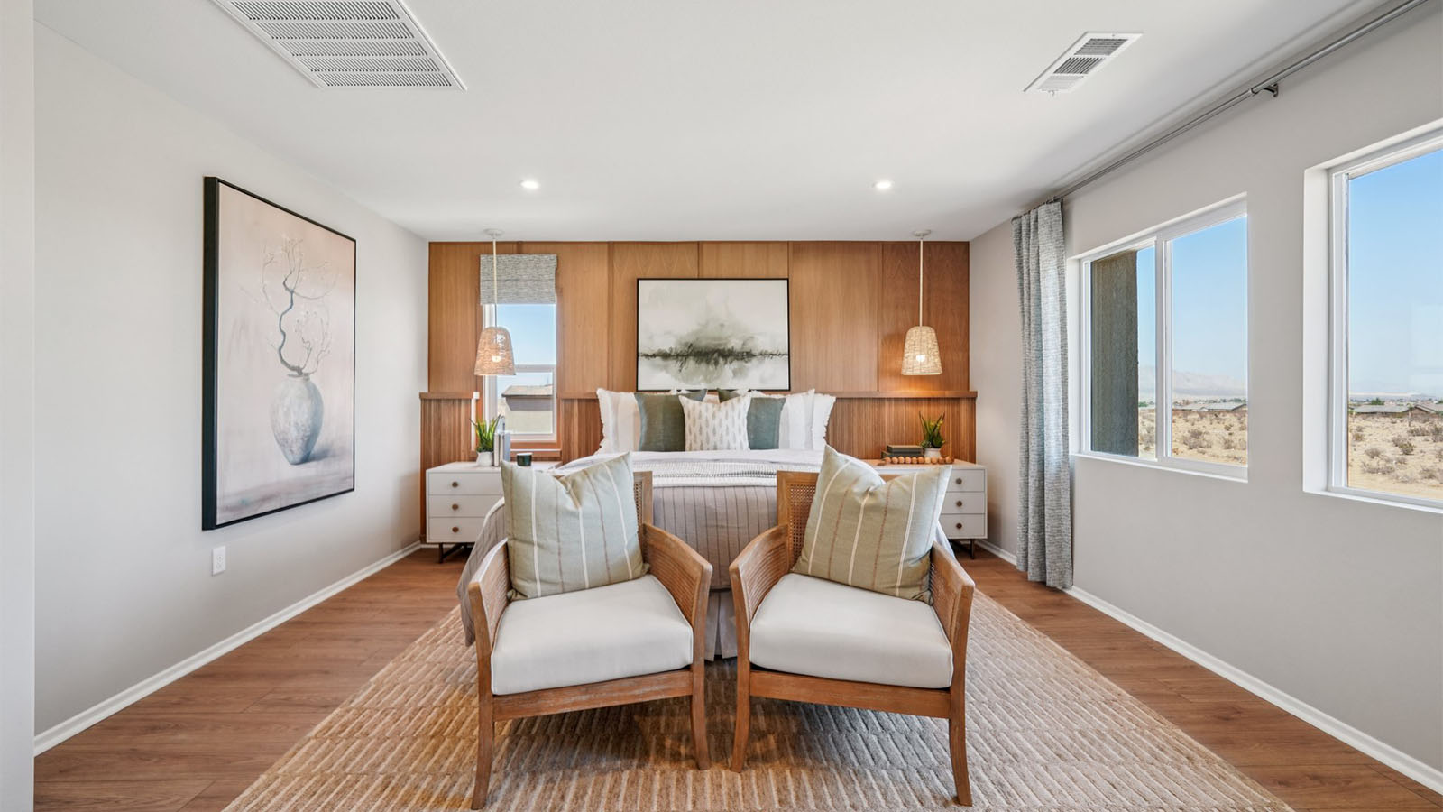 Primary bedroom with king bed and laminate wood flooring