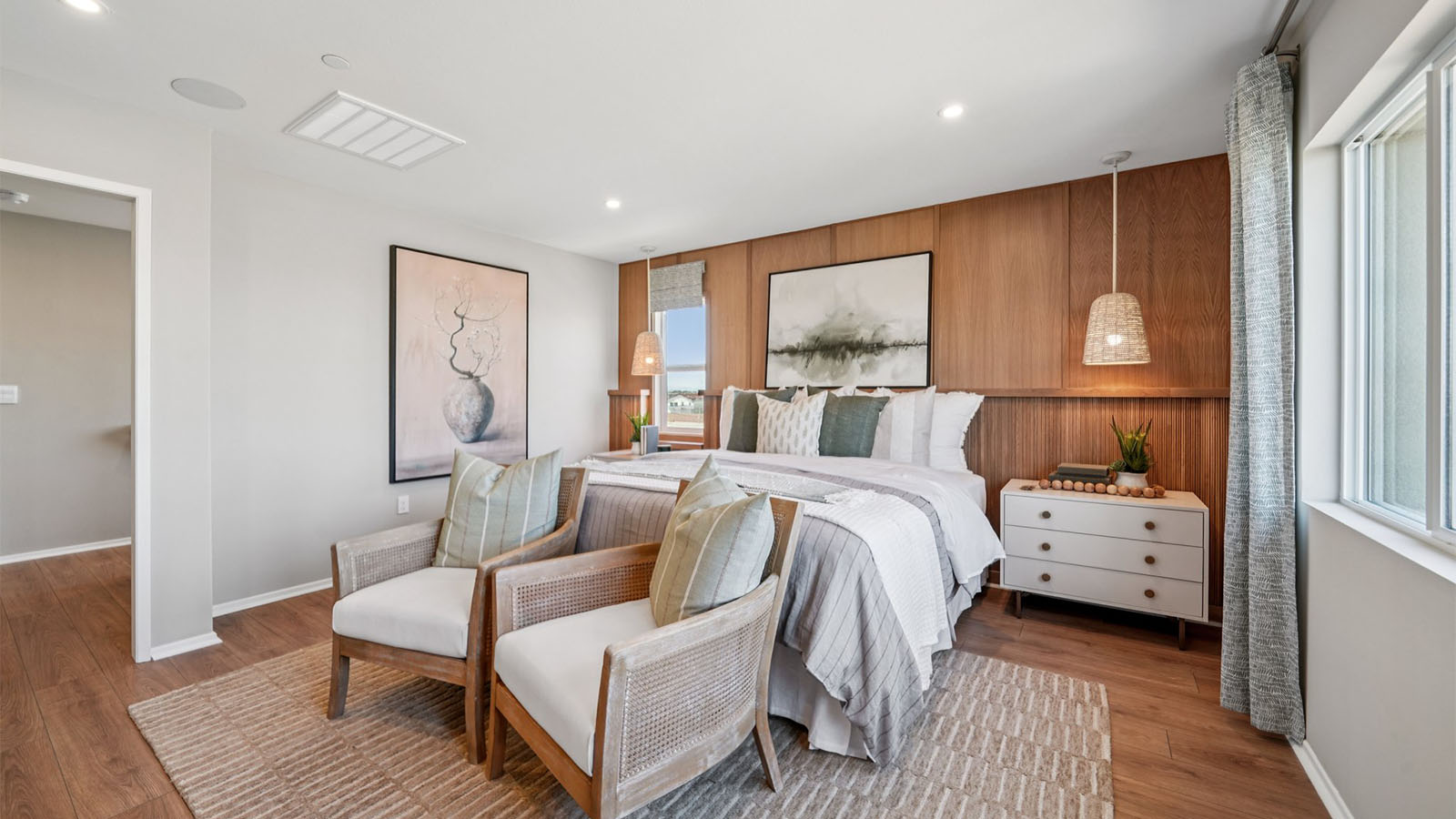 Primary bedroom with king bed and laminate wood flooring