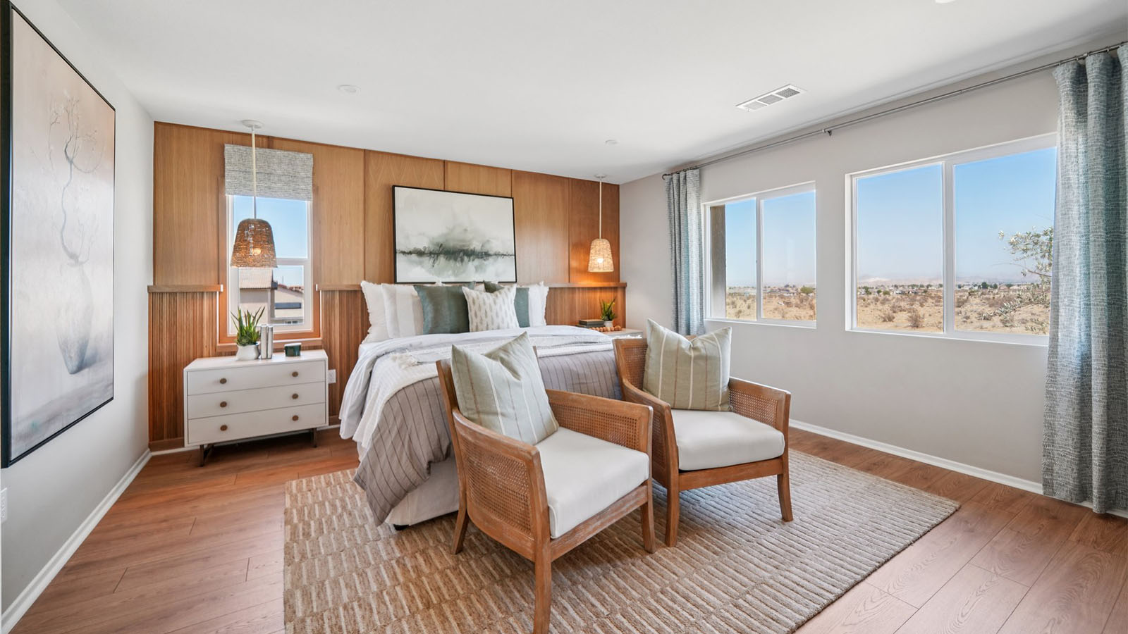 Primary bedroom with king bed and laminate wood flooring