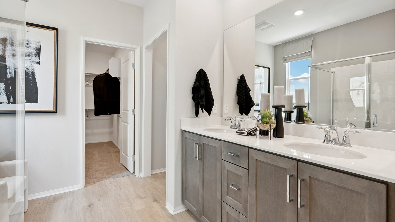Primary bathroom with double sinks and a spacious walk-in closet