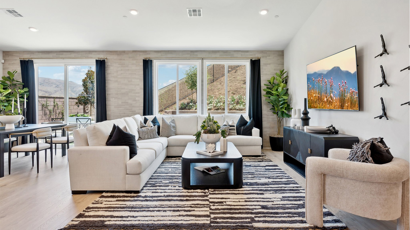 Photo of a great room with large windows looking into the backyard