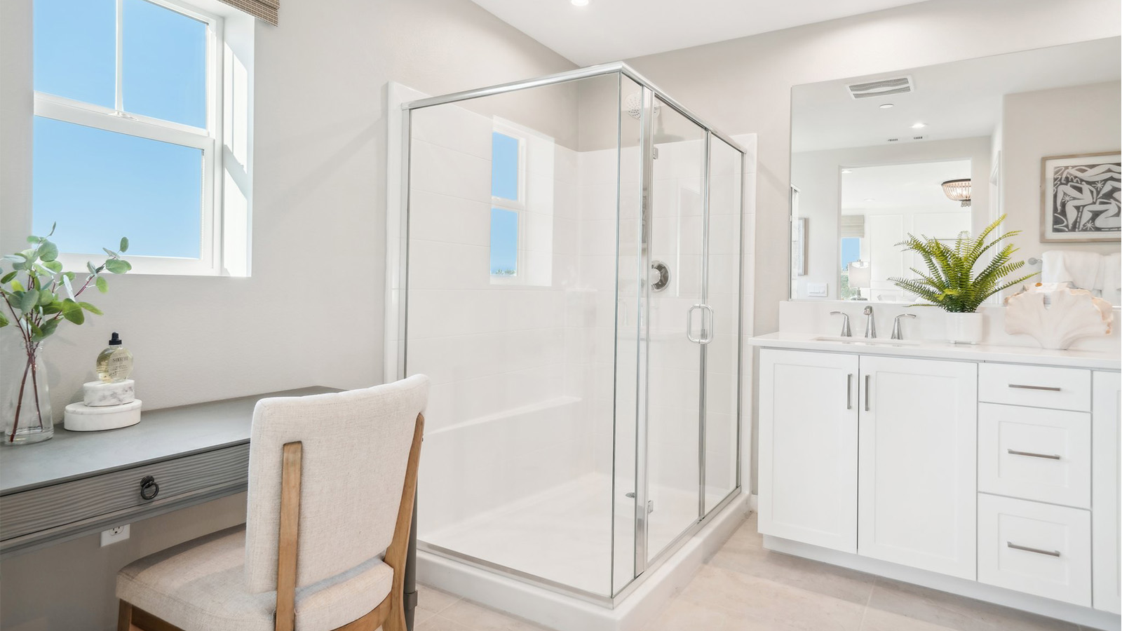 Primary bathroom with dual vanities and shower