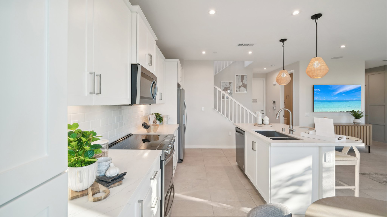 Modern kitchen with white cabinets quartz countertops and stainless steel appliances