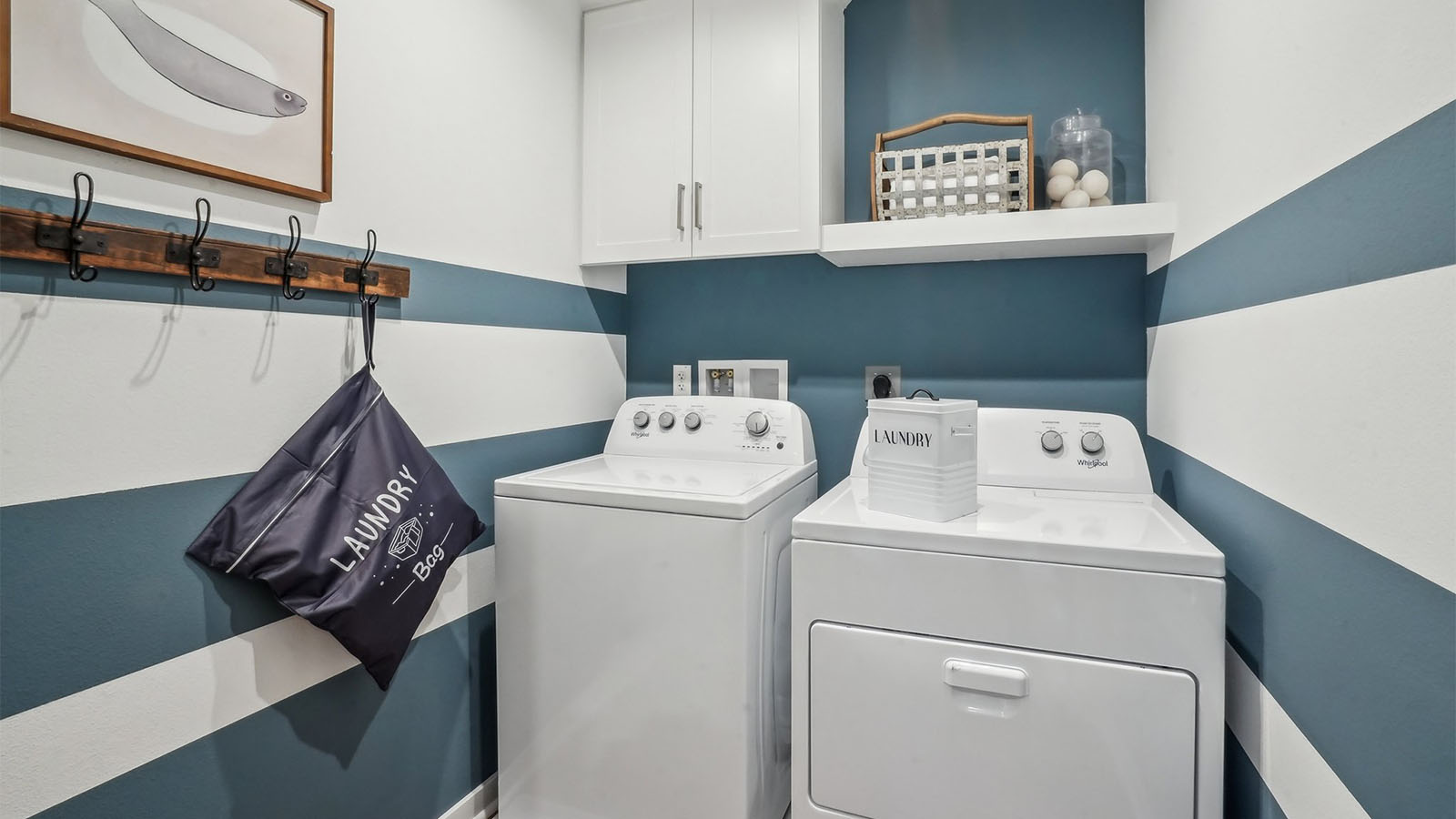Laundry room with upper cabinet and shelf and washer and dryer