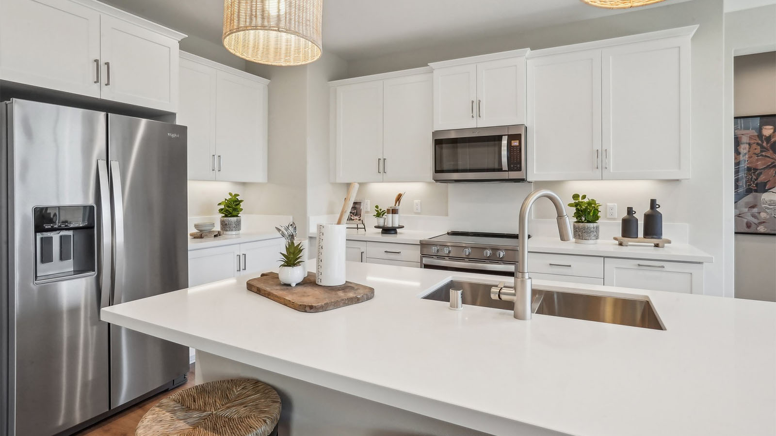 Modern kitchen with white cabinets quartz countertops and stainless steel appliances