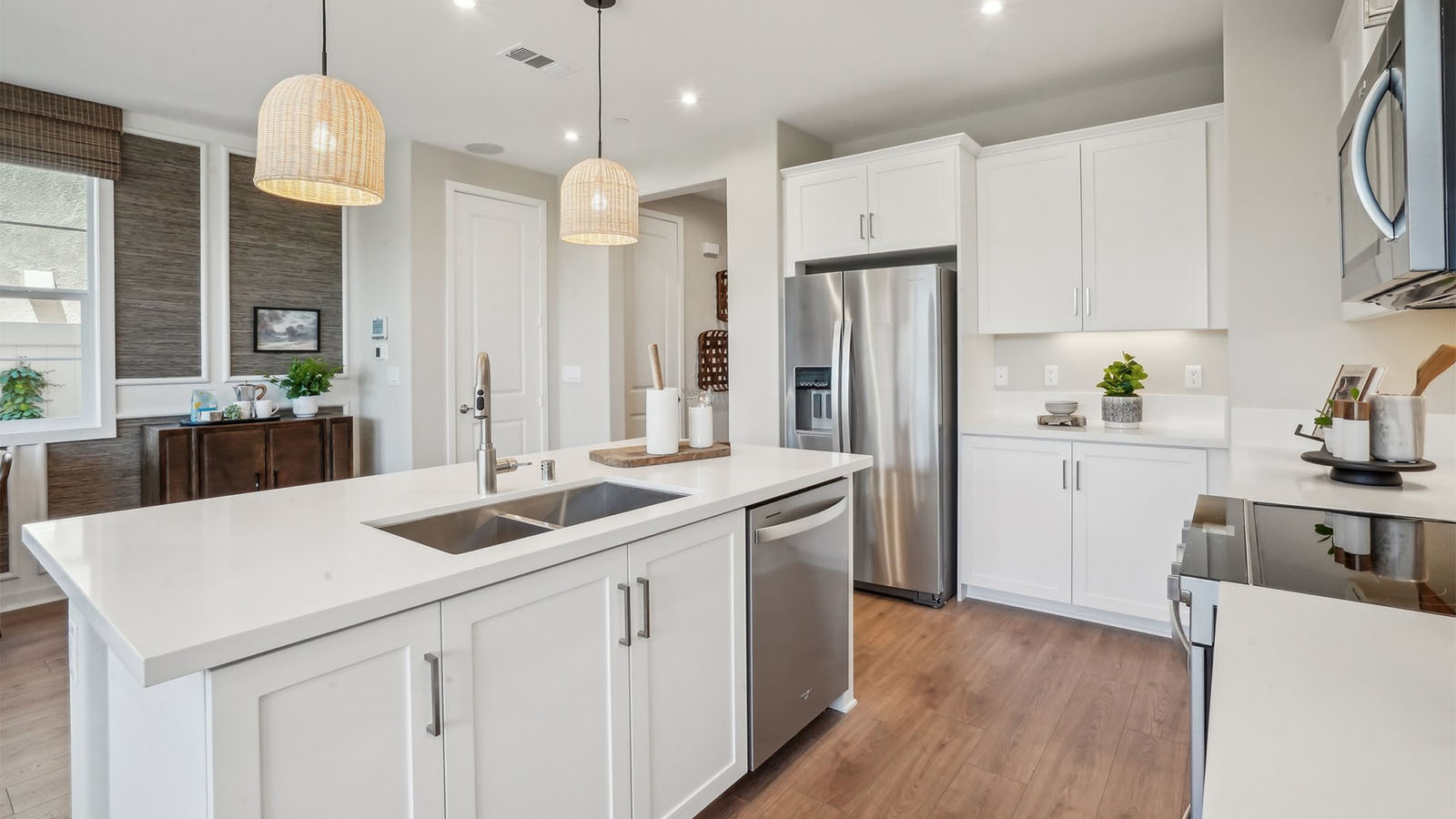 Modern kitchen with white cabinets quartz countertops and stainless steel appliances