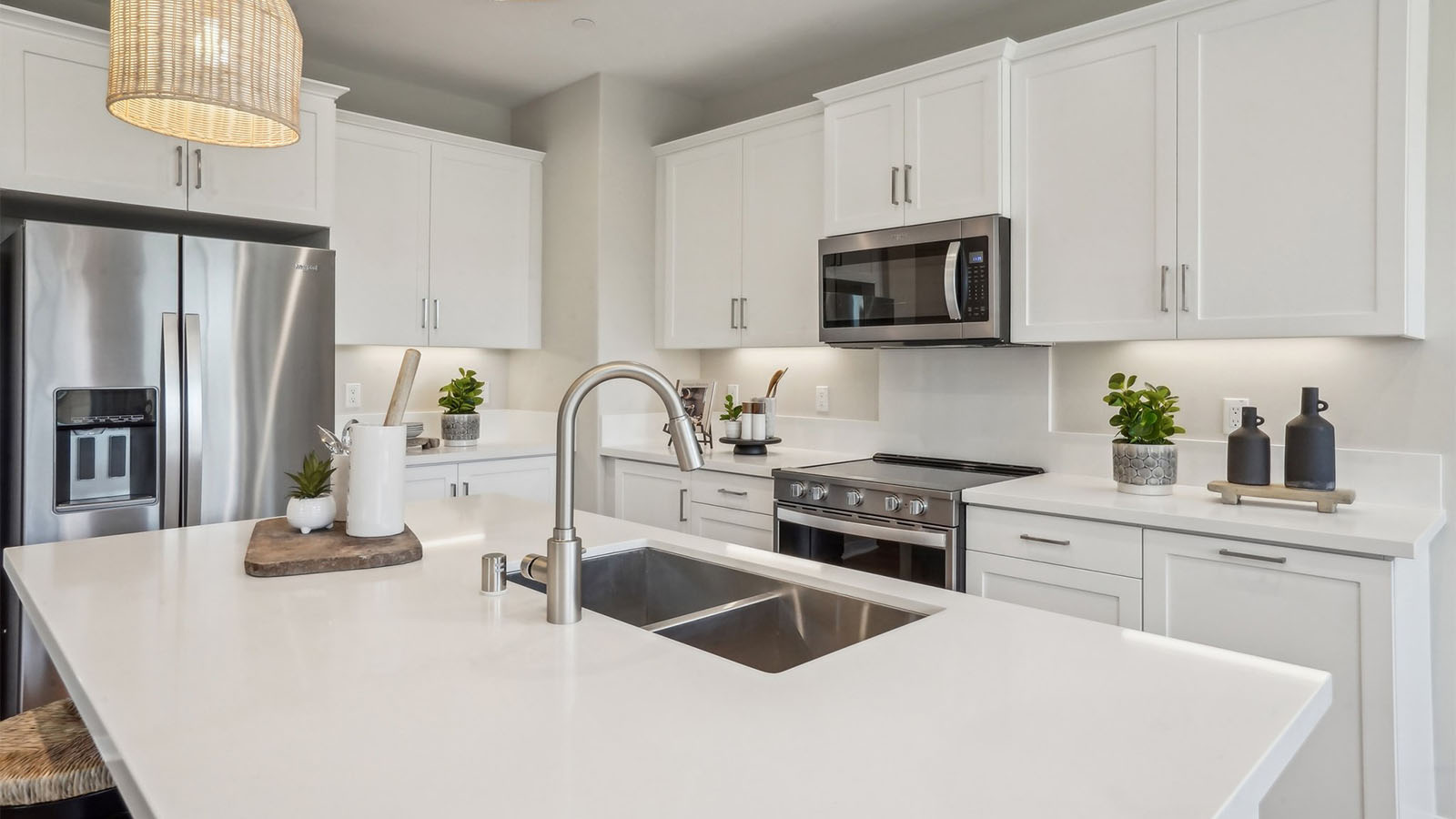 Modern kitchen with white cabinets quartz countertops and stainless steel appliances