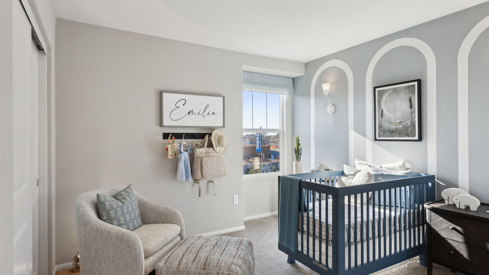 Nursery with crib, dresser, and accent wall