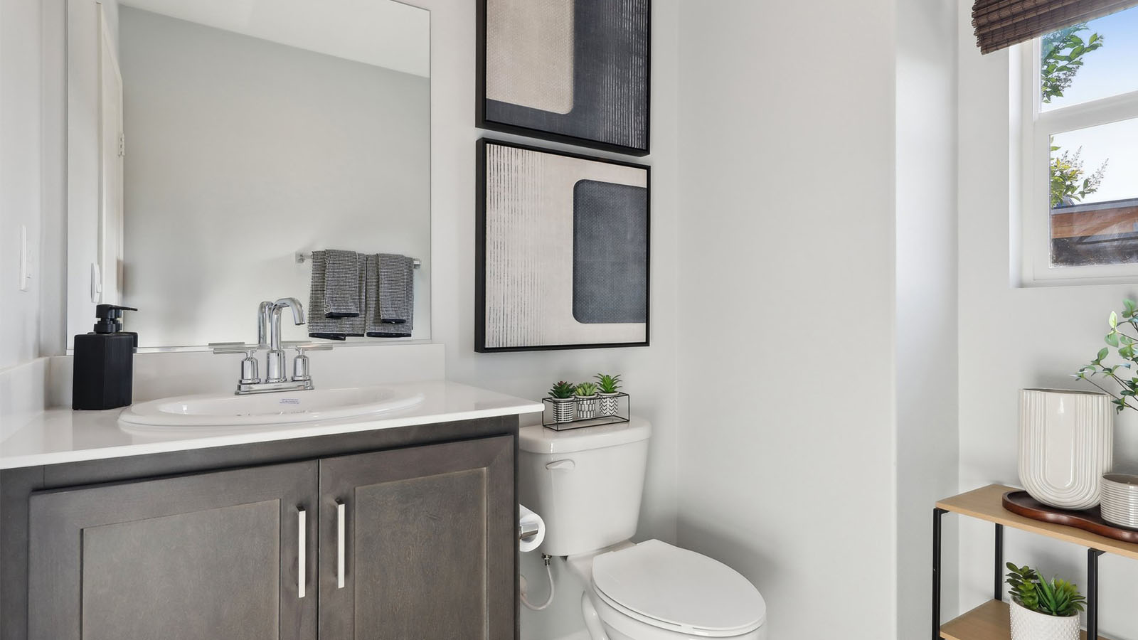 Secondary bedroom with dual sinks and brown cabinets