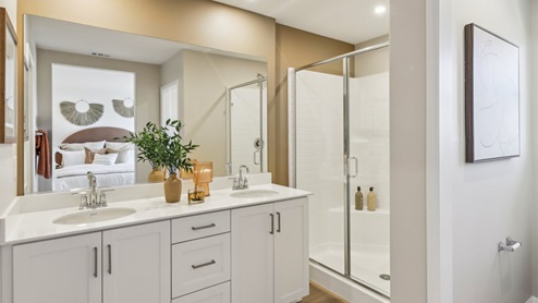Secondary bathroom with dual sinks and shower