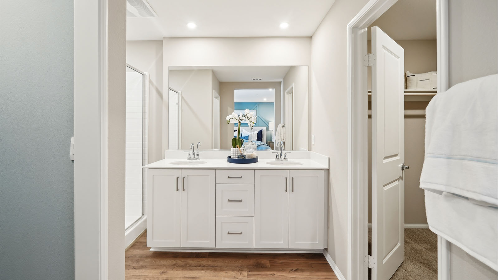 Primary bathroom with dual sinks with white countertops and shower