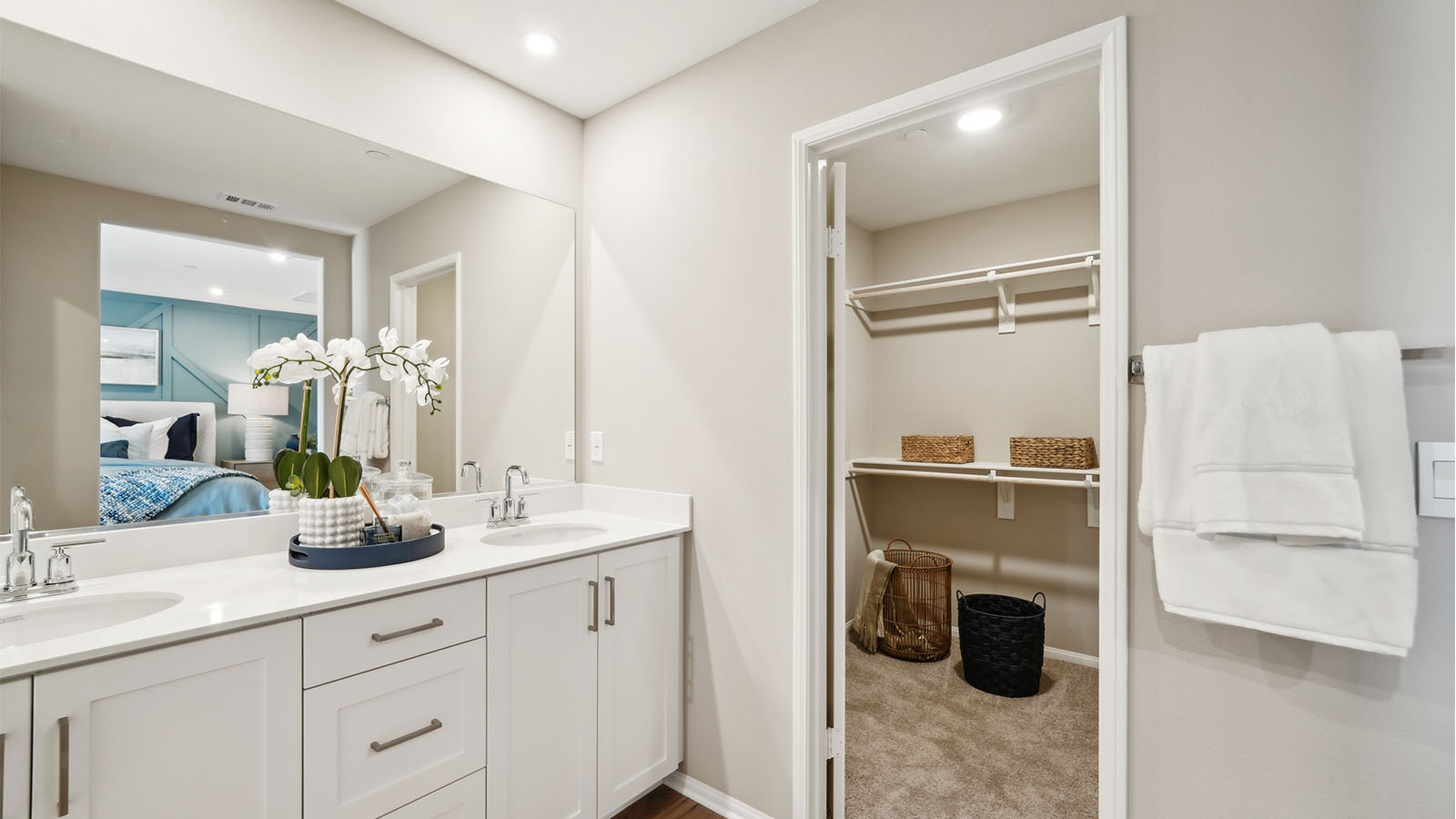 Primary bathroom with dual sinks with white countertops and shower