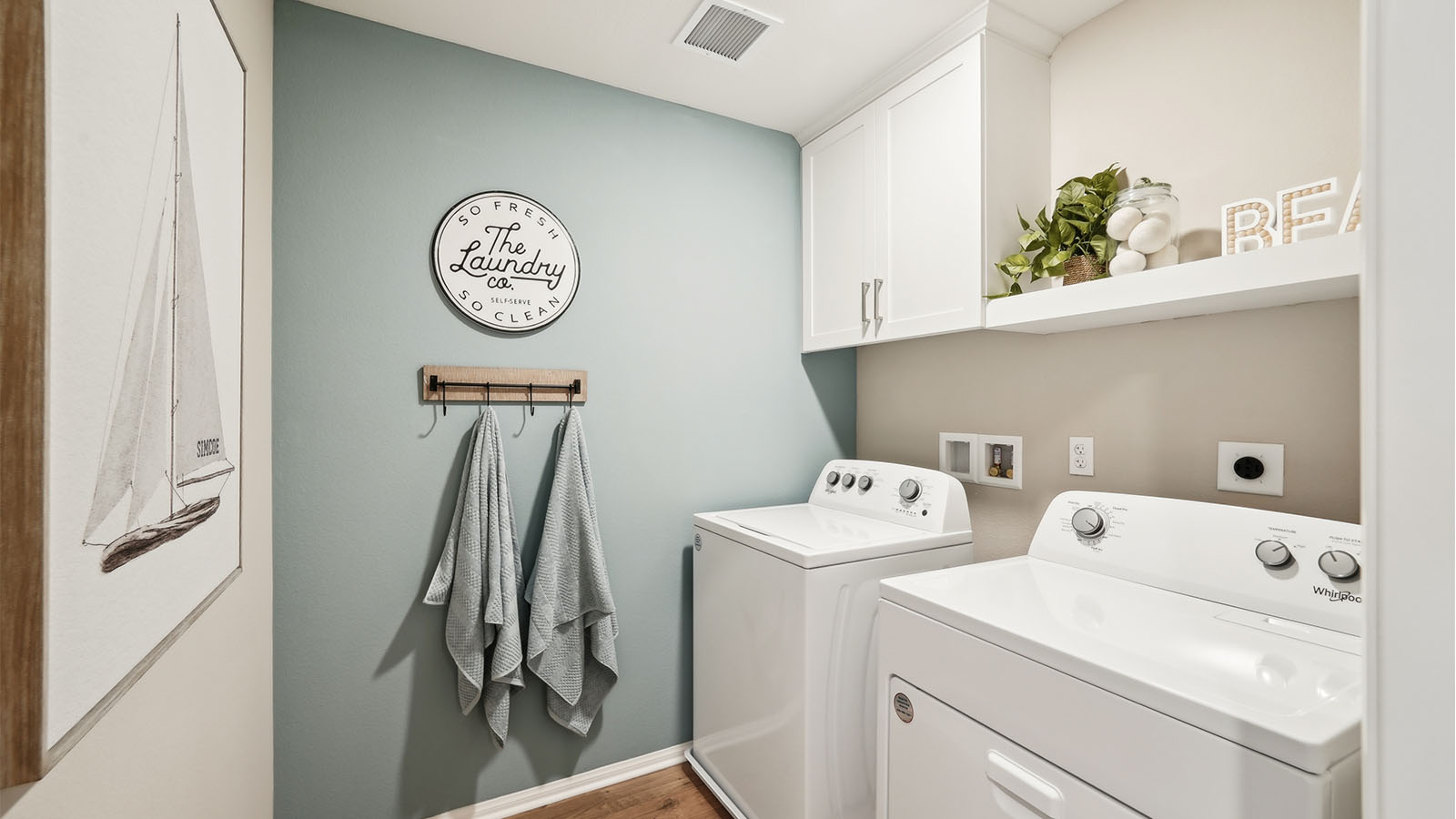 Laundry room with white upper cabinet and shelve