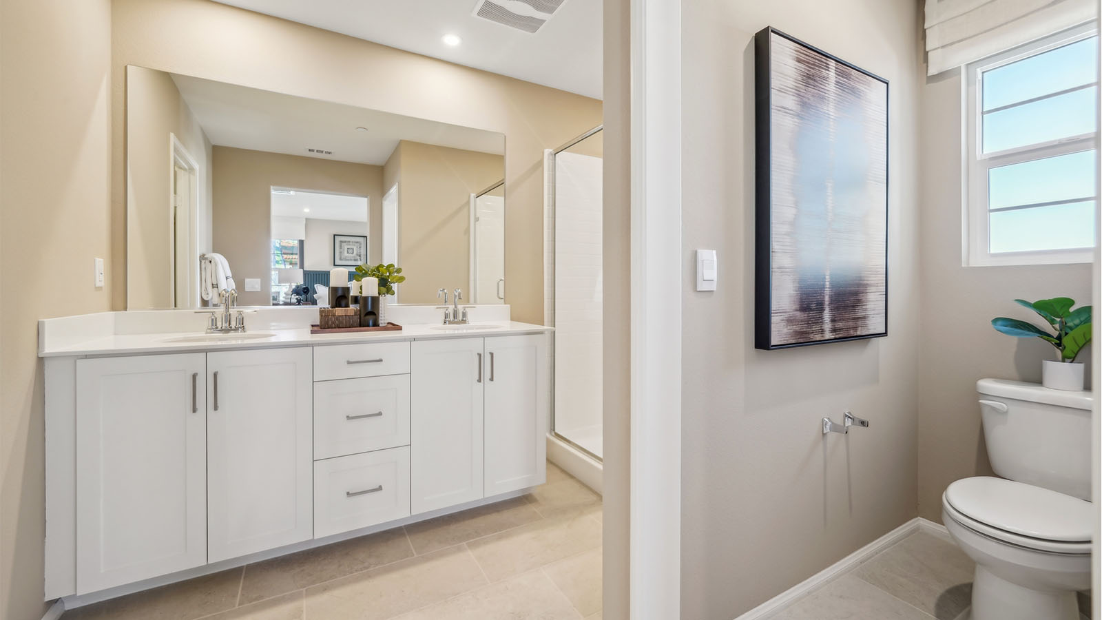 Primary bathroom with white cabinets and countertops with dual sinks