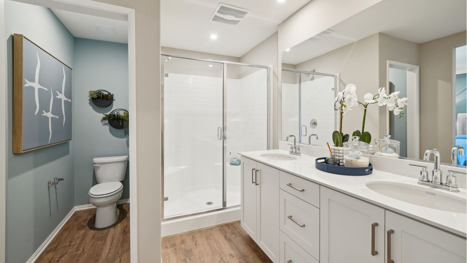 Primary bathroom with dual sinks with white countertops and shower