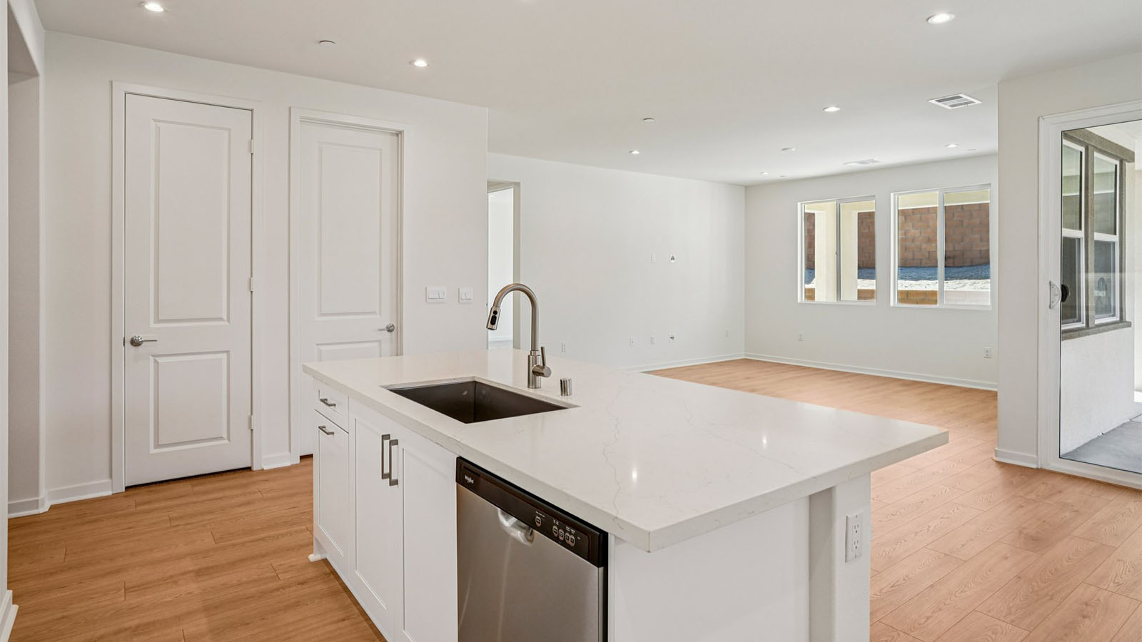 Open-concept kitchen with white cabinets and stainless steel appliancees
