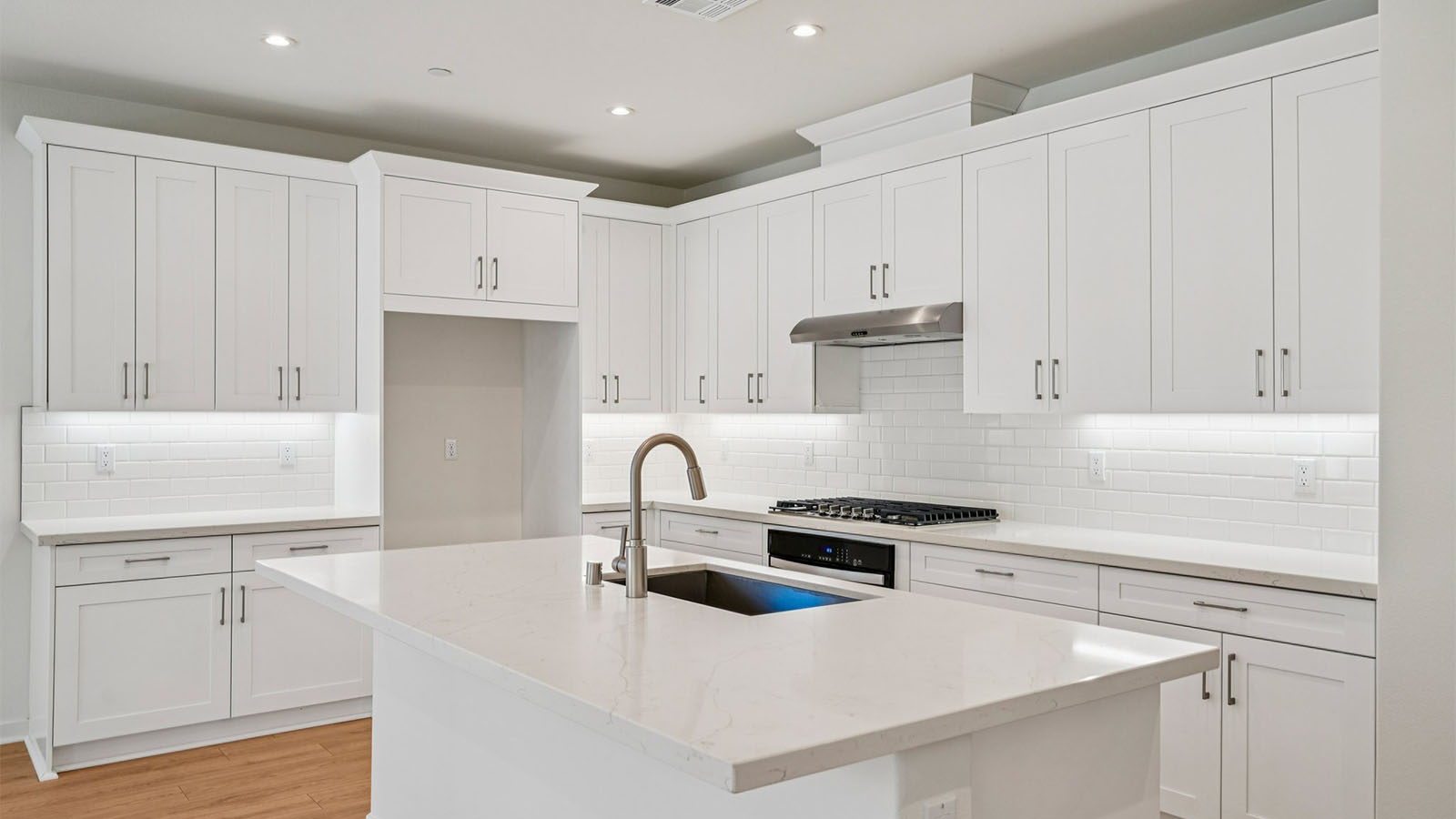 Open-concept kitchen with white cabinets and stainless steel appliancees
