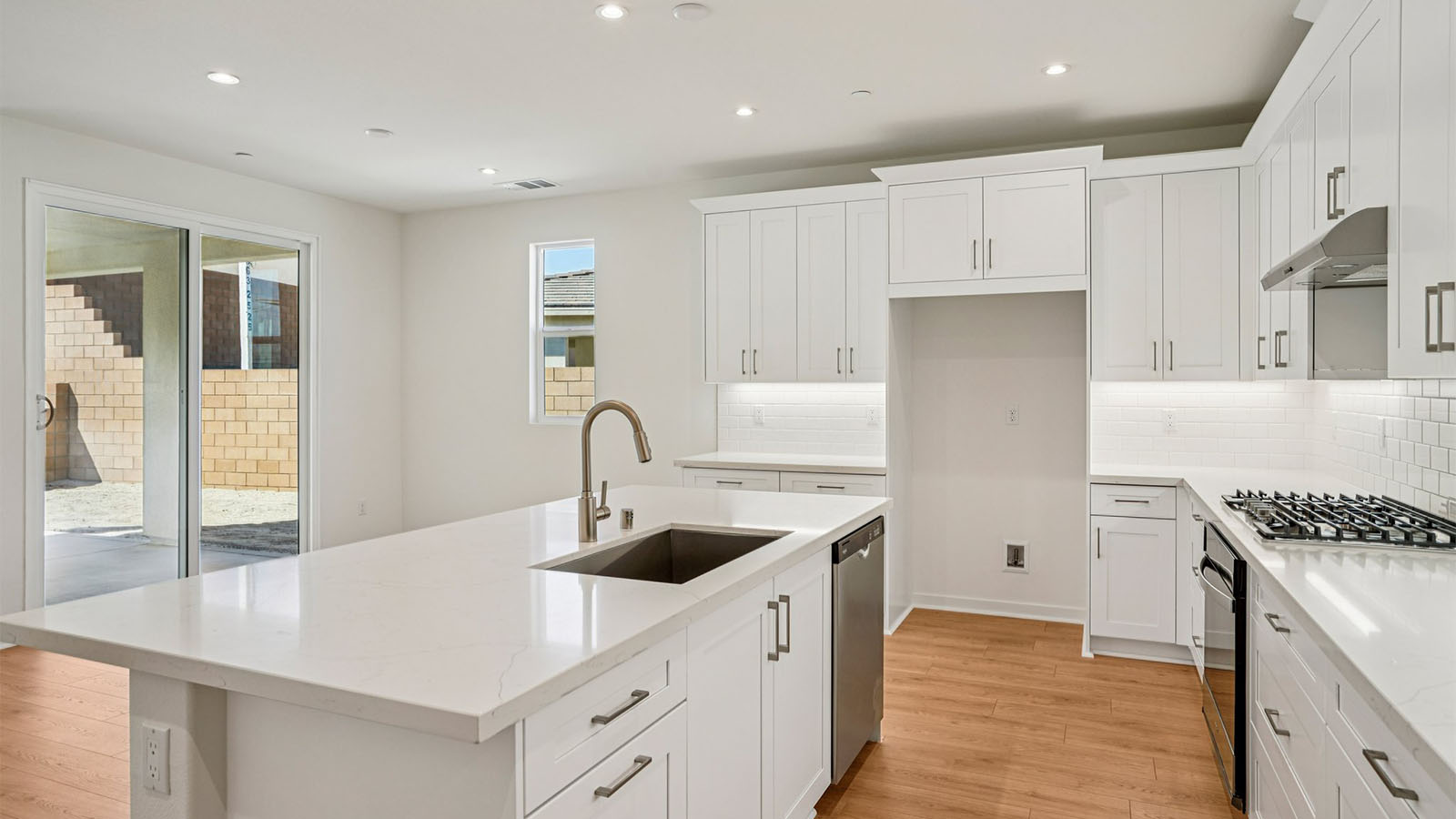 Open-concept kitchen with white cabinets and stainless steel appliancees