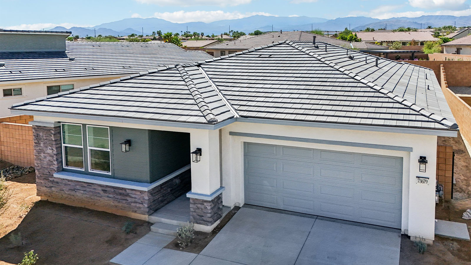 One-story desert contemporary home with stone veneer and two-car garage