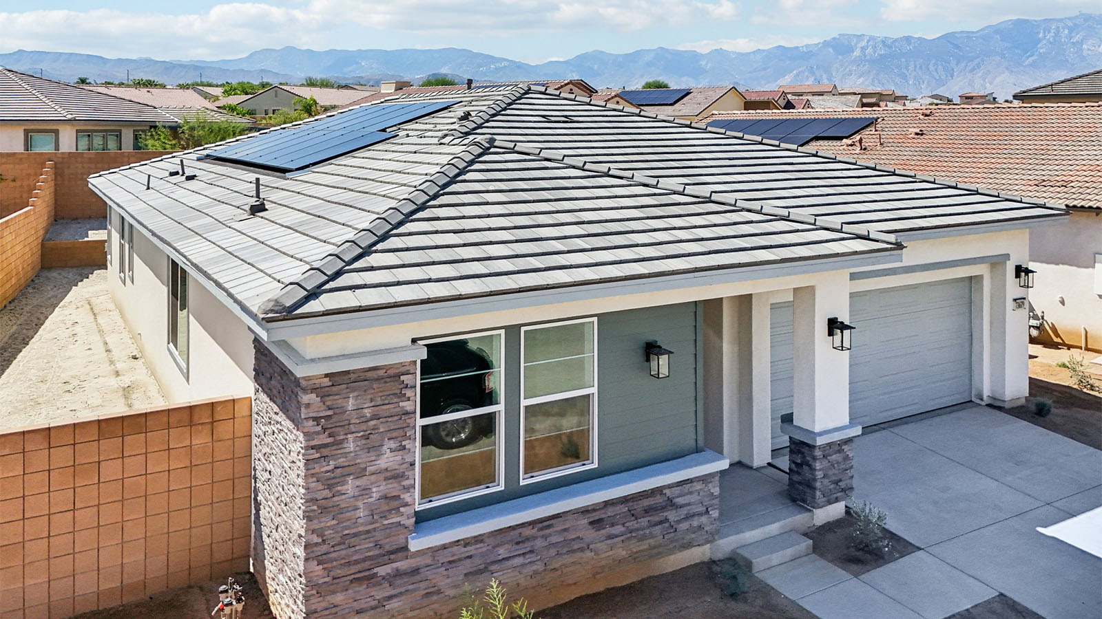 One-story desert contemporary home with stone veneer and two-car garage