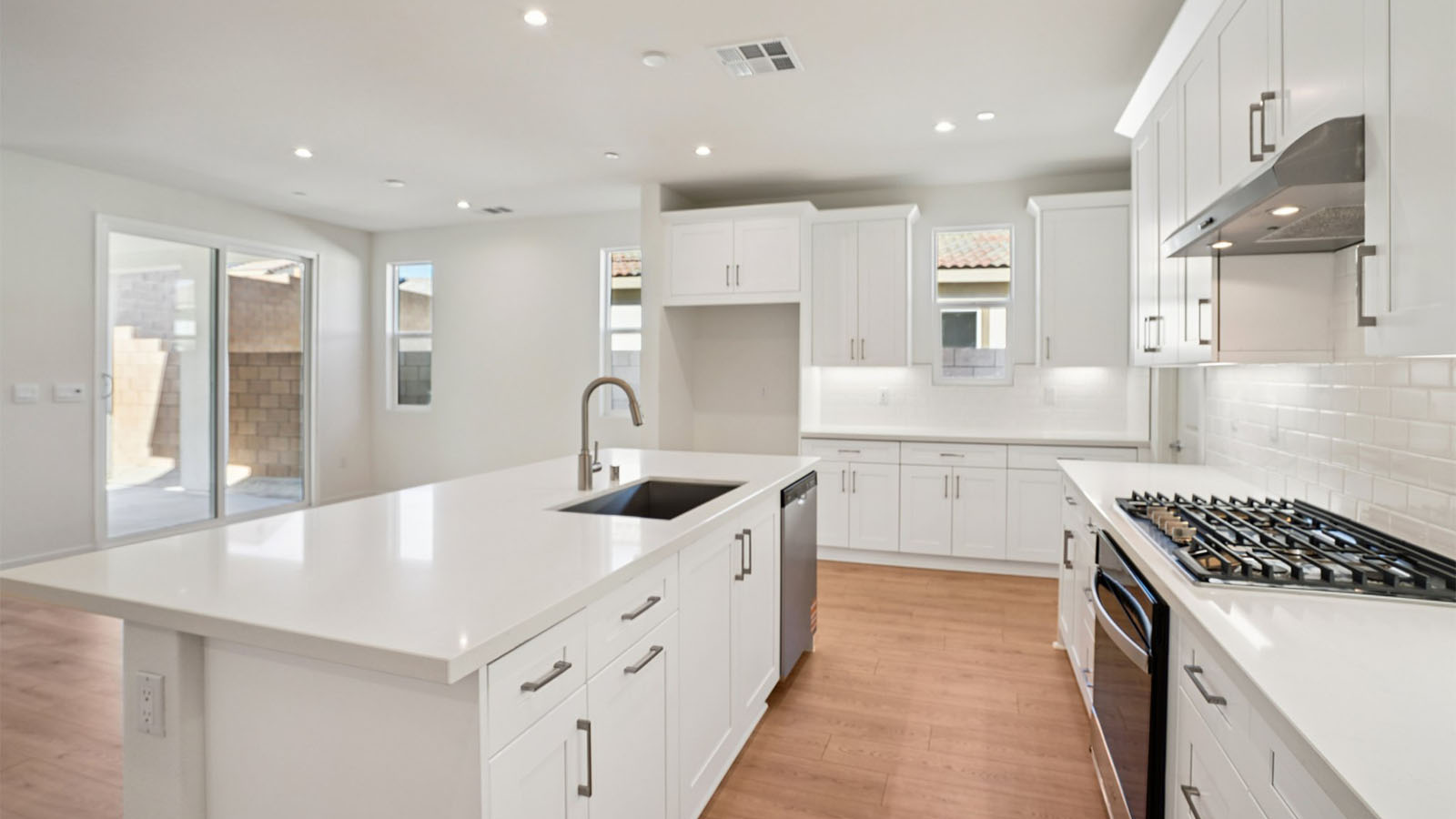 Open-concept kitchen with white cabinets and stainless steel appliances