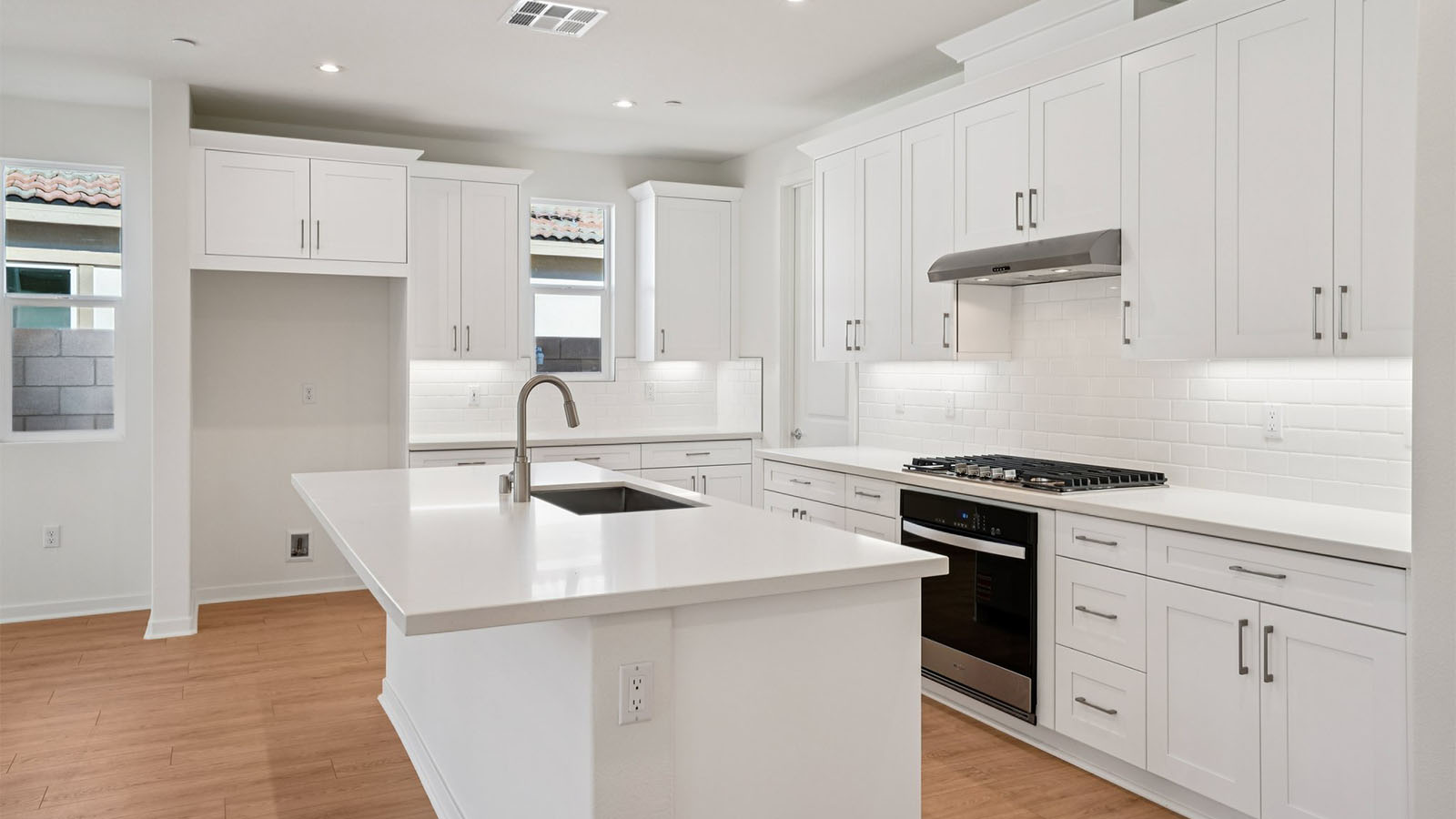 Open-concept kitchen with white cabinets and stainless steel appliances