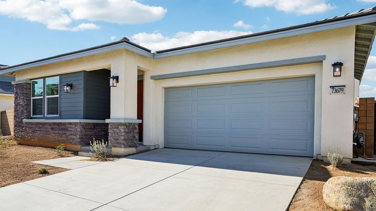 One-story desert contemporary home with stone veneer and two-car garage