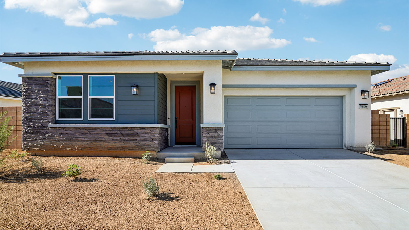 One-story desert contemporary home with stone veneer and two-car garage