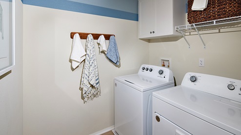 Laundry room with white cabinetry and wire shelving