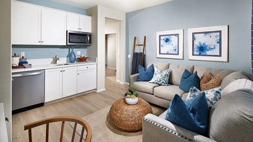Multigen private suite kitchenette with white cabinets and living space
