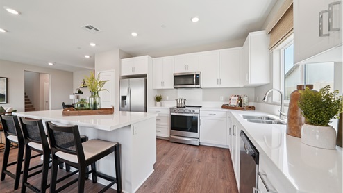 Spacious kitchen with white cabinets and an island