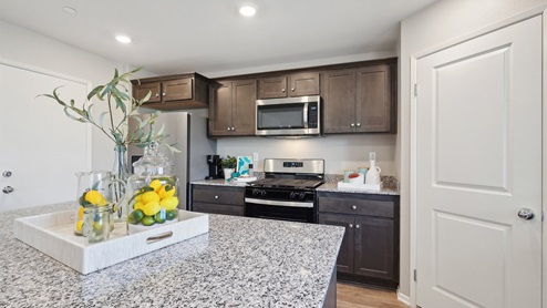 Kitchen with granite countertops, an island, and stainless-steel appliances