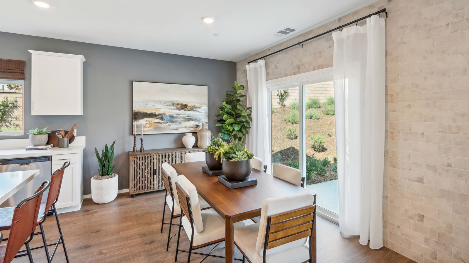 Dining table next to windows looking out into spacious backyard