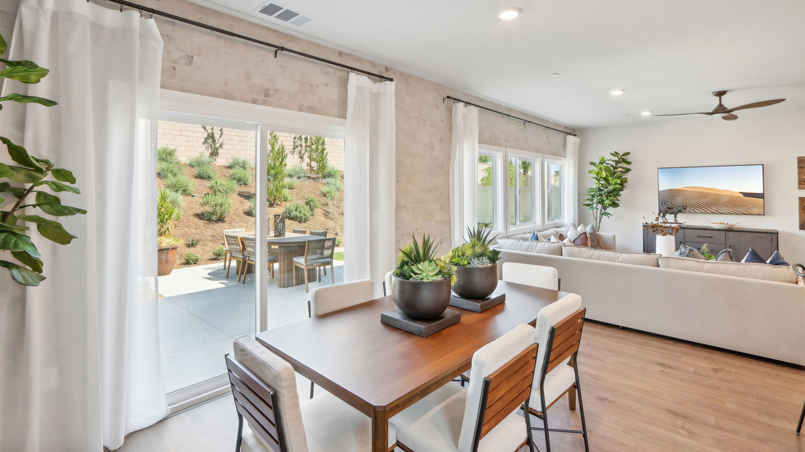 Dining table next to windows looking out into spacious backyard