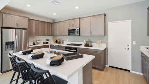 Kitchen with white quartz countertops and stainless steel appliances