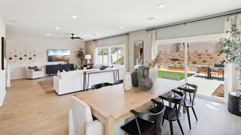 Dining table next to large windows looking into spacious backyard